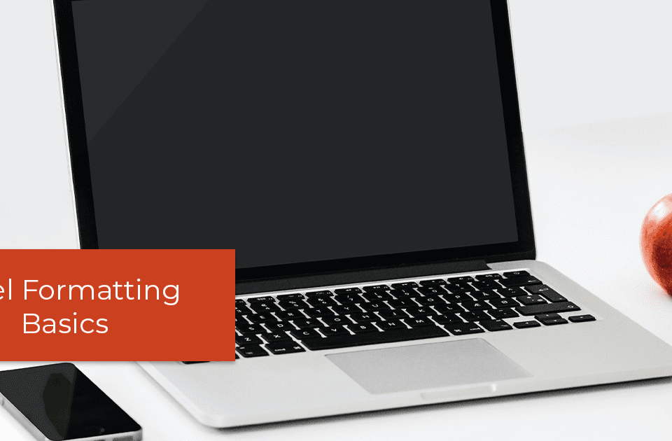 A laptop, cellphone, and apple on a white table.